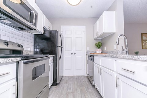 a kitchen with stainless steel appliances and white cabinets