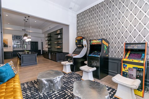 a living room with two arcade machines and a couch
