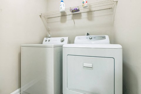 A  washing machine and dryer in a small laundry room at The Atlantic Loring Heights, Atlanta, Georgia