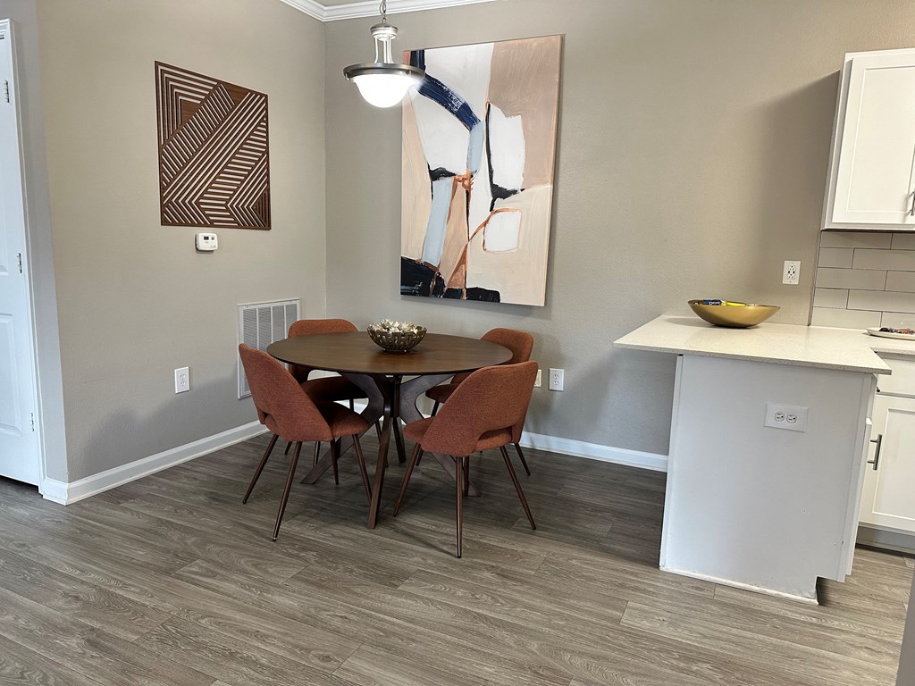a dining area with a table and four chairs