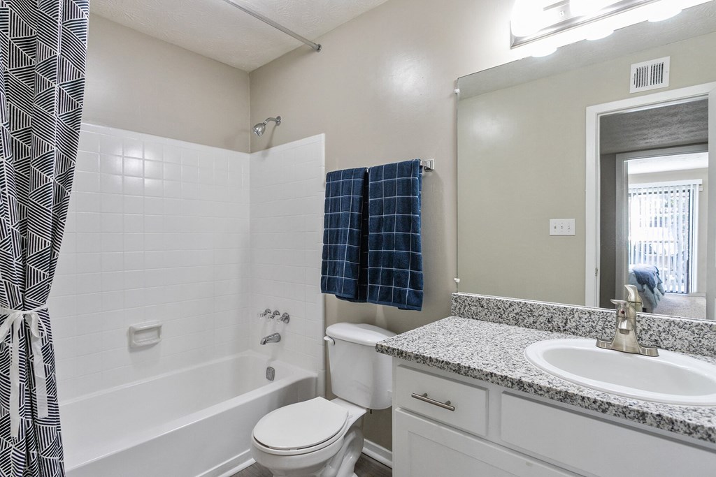 Bathroom with a shower toilet and sink and a mirror at The Atlantic Briarcliff, Atlanta
