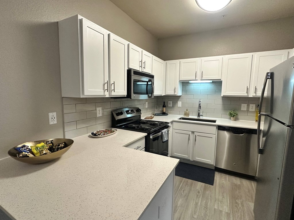 a kitchen with white cabinets and stainless steel appliances