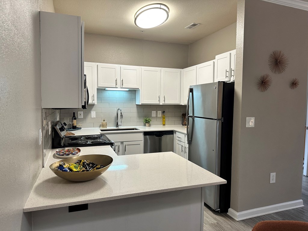 a kitchen with white cabinets and stainless steel appliances