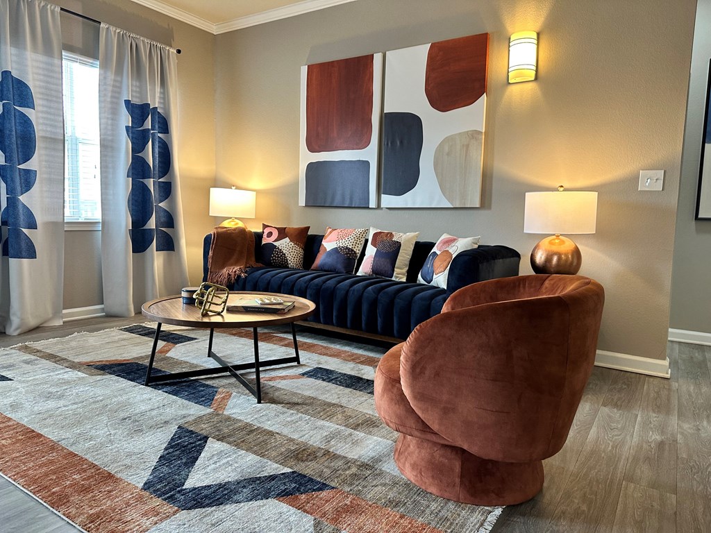 a living room with a blue couch and two brown chairs