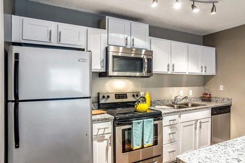 a kitchen with stainless steel appliances and white cabinets