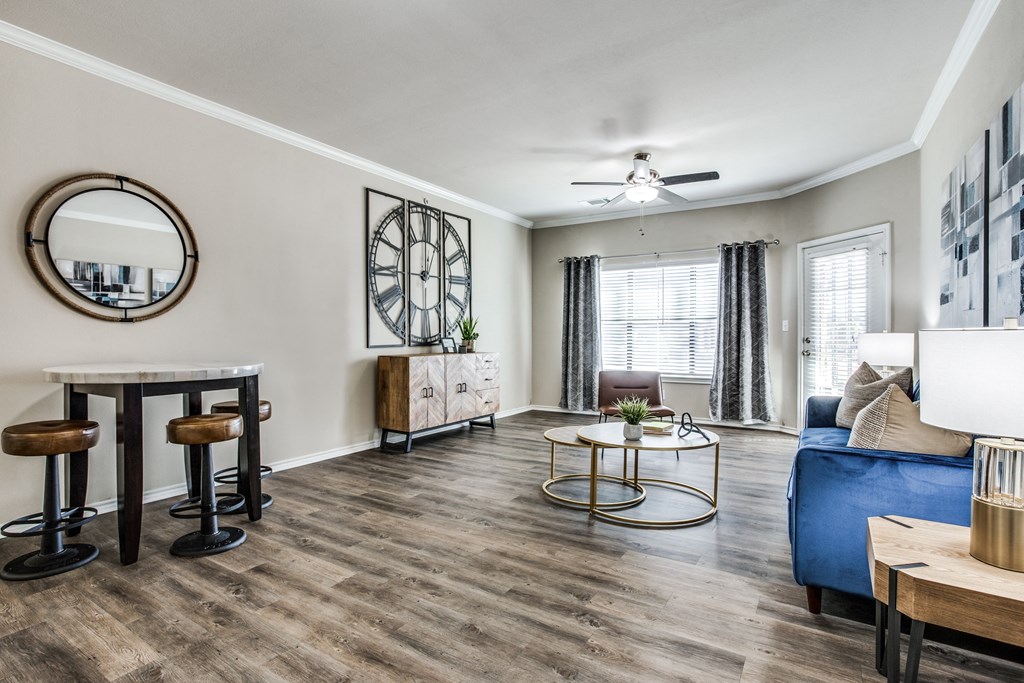 a living room with a large clock on the wall at Village of Hawks Creek Apartments, Westworth Village Texas