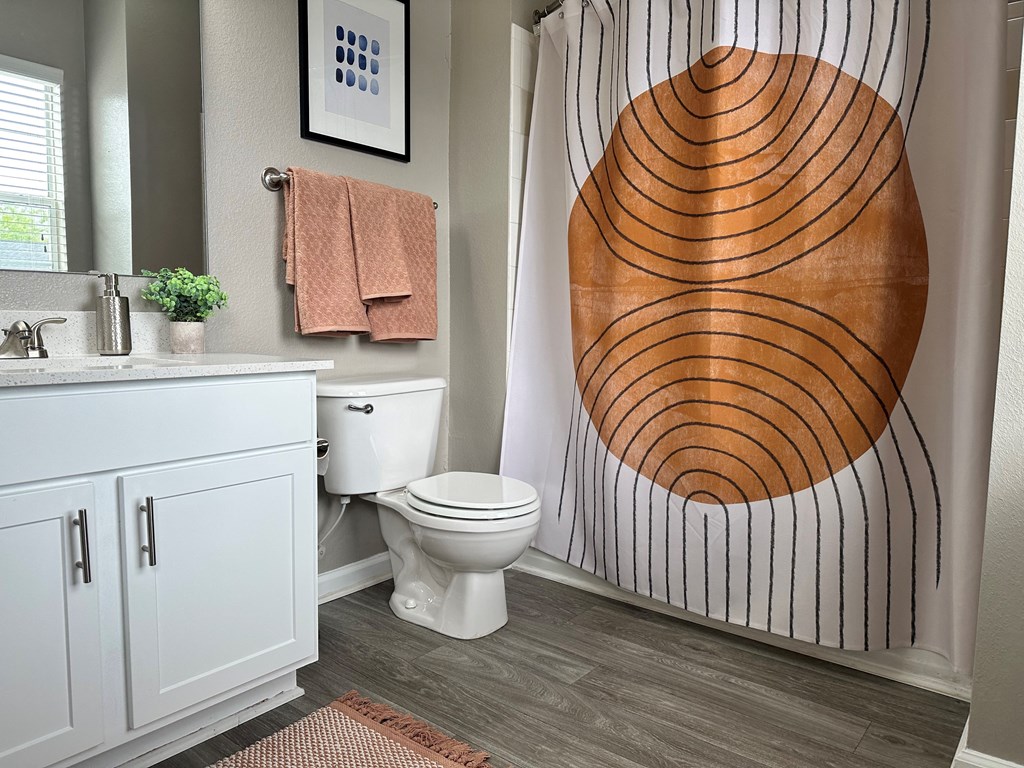 a bathroom with a white sink and toilet next to a shower with a wooden design