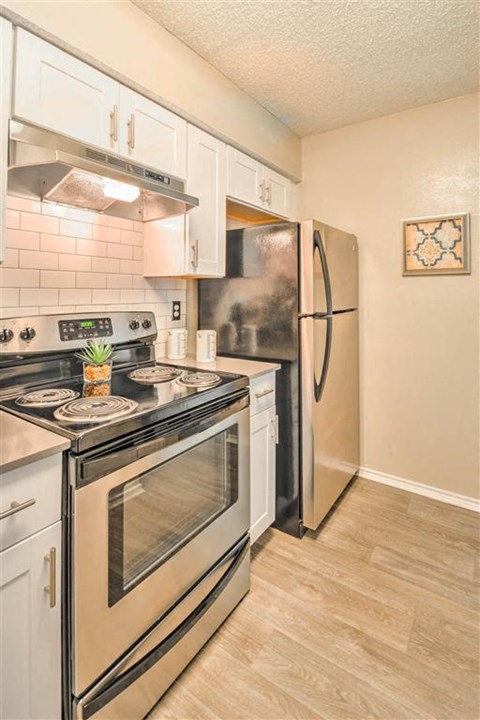 a kitchen with stainless steel appliances and a refrigerator