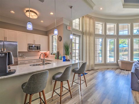a kitchen with an island and chairs in front of a window