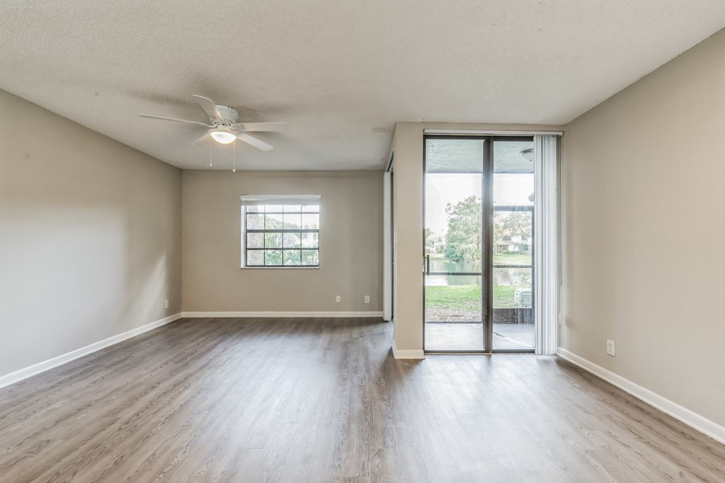 an empty living room with a sliding glass door to a patio. Select units.