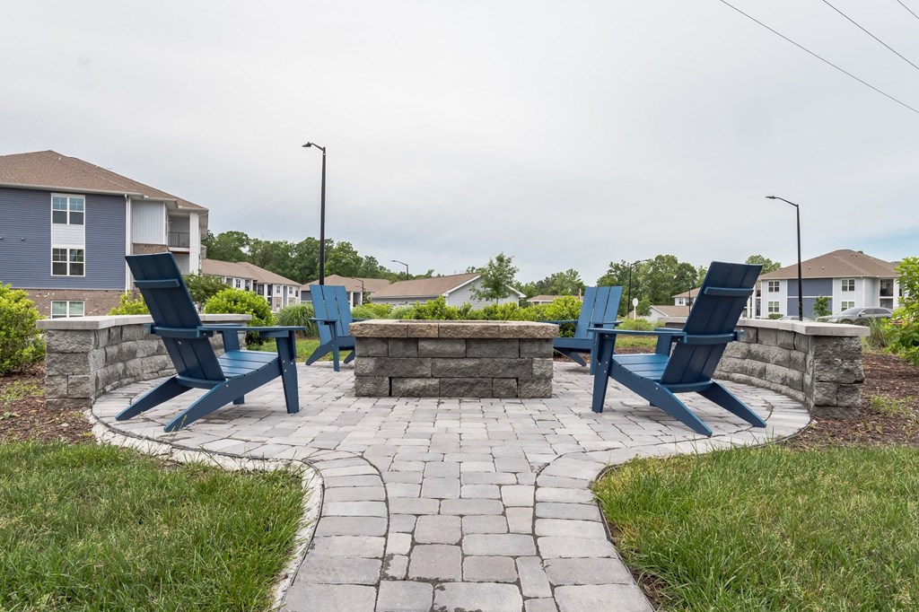 Stone patio with blue chairs and a stone fire pit at The Atlantic Mountain Island, Charlotte, North Carolina
