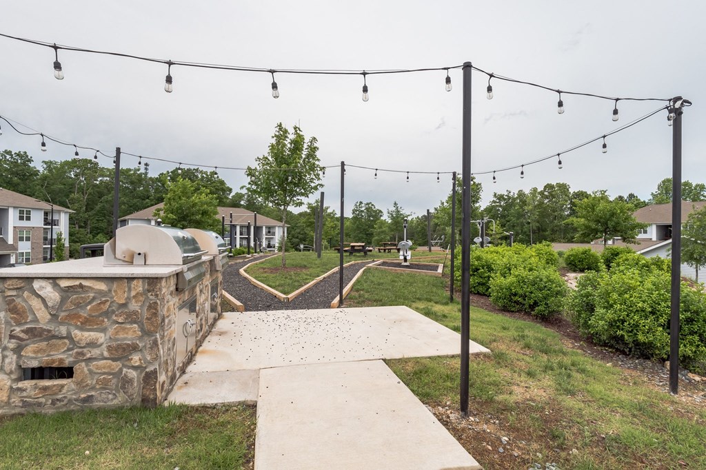 View of a concrete walkway with lights hanging above it at The Atlantic Mountain Island, Charlotte, 28216