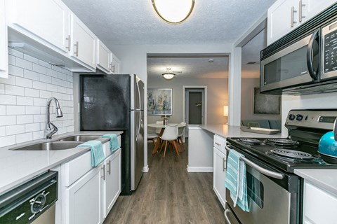 a kitchen with stainless steel appliances and white cabinets