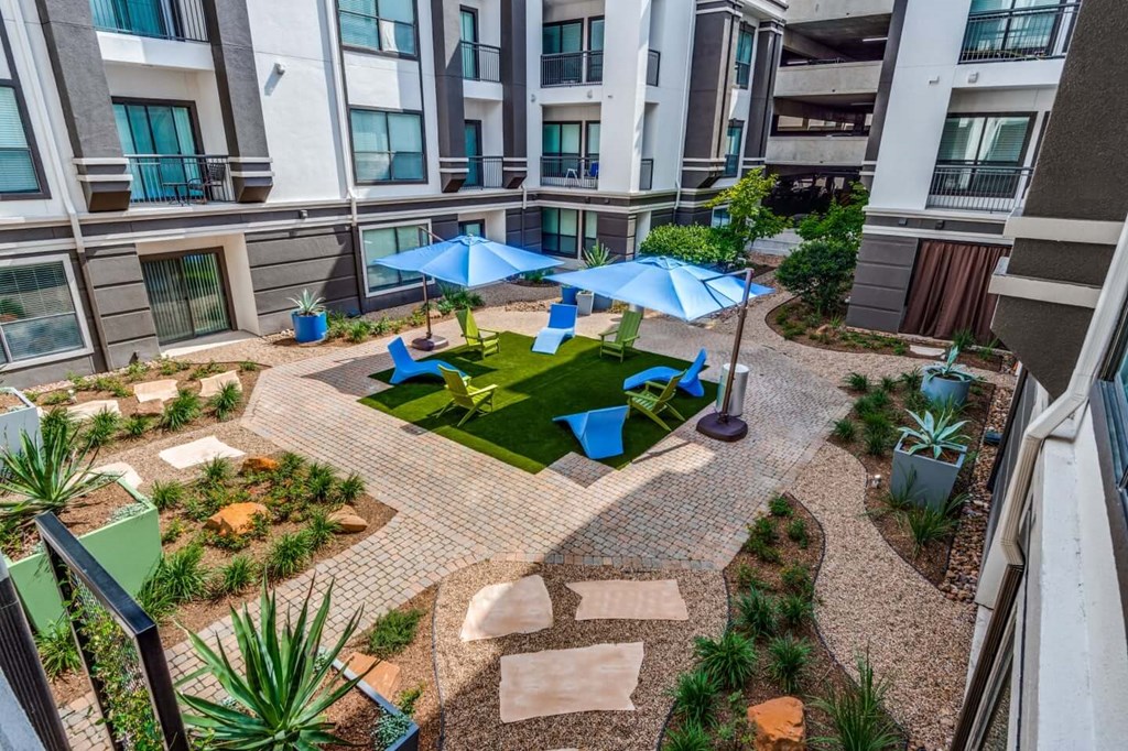 A patio with a table and chairs surrounded by a brick wall. at Montecito Apartments, Texas