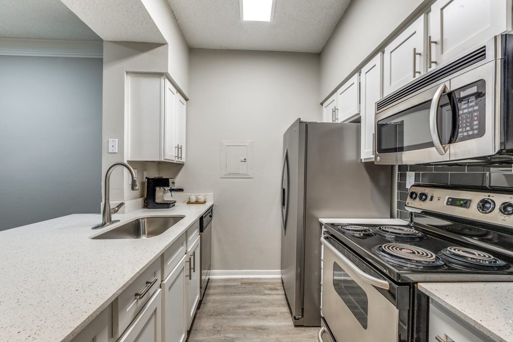 A kitchen with a stove, sink, and refrigerator. at Montecito Apartments, Houston, 77056