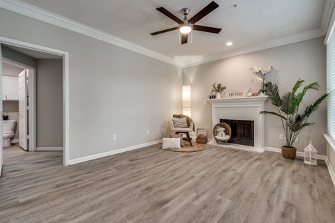 A living room with a fireplace and a ceiling fan.