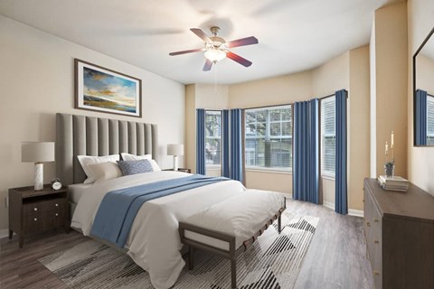 A bedroom with a large bed and a ceiling fan.