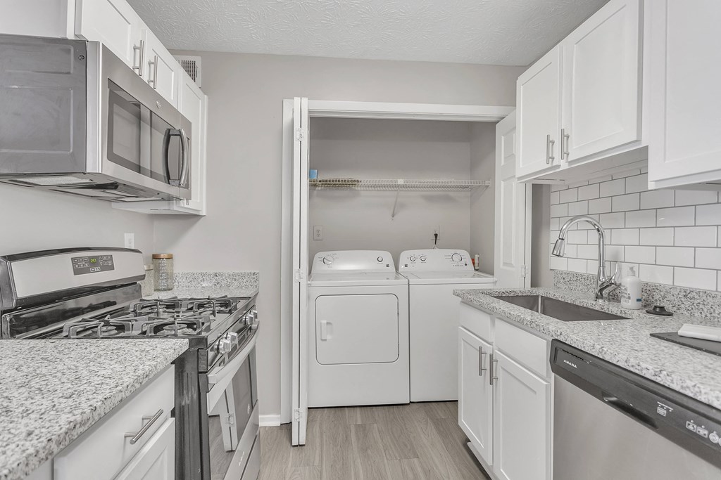 Kitchen with white appliances and granite counter tops at The Atlantic Briarcliff, Atlanta, GA