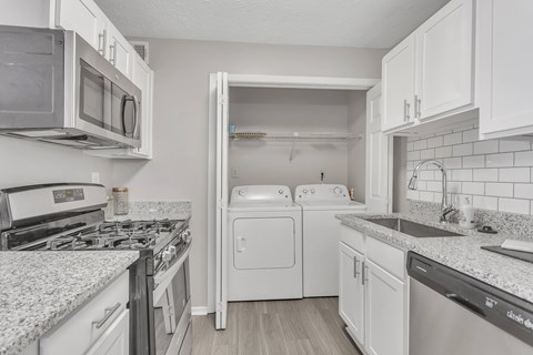a kitchen with white appliances and granite counter tops