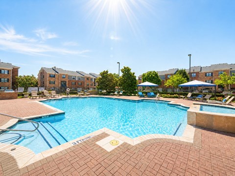 A sunny day at the pool with apartment buildings in the background.