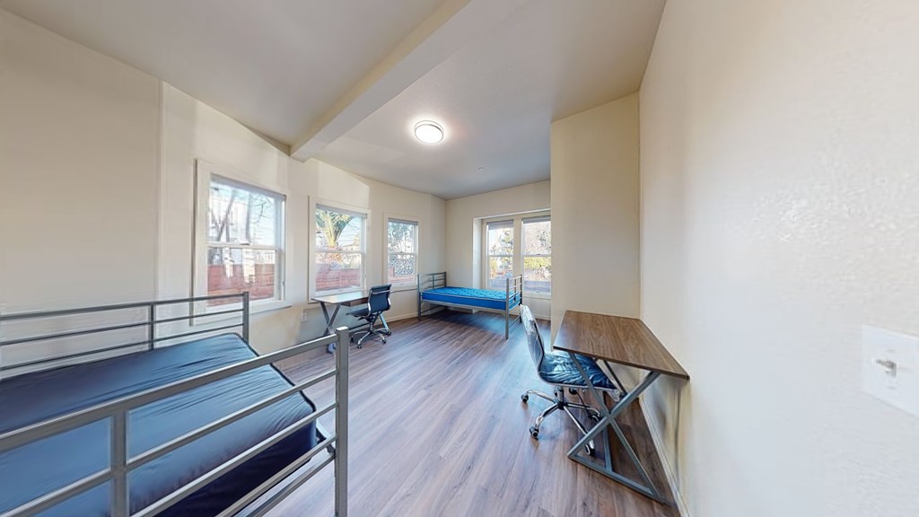 A room with a balcony and a table with chairs.