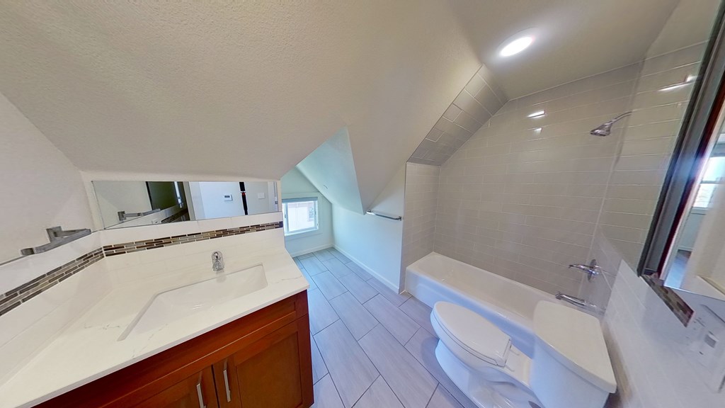A white bathroom with a sink, toilet, and bathtub.