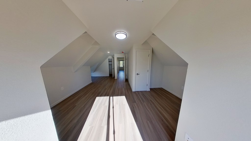 A long white hallway with a light on the ceiling.