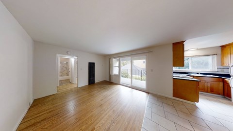 A spacious room with wooden floors and white walls.