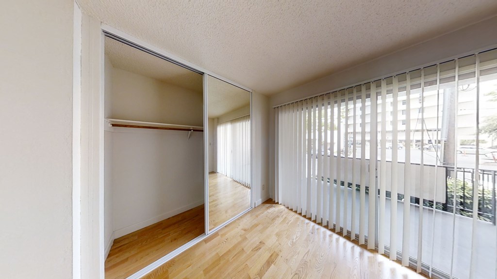 A room with a sliding door and a window with blinds.