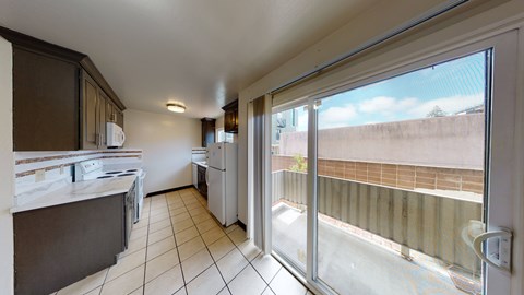 A kitchen with a white counter top and a window with a view of a building.