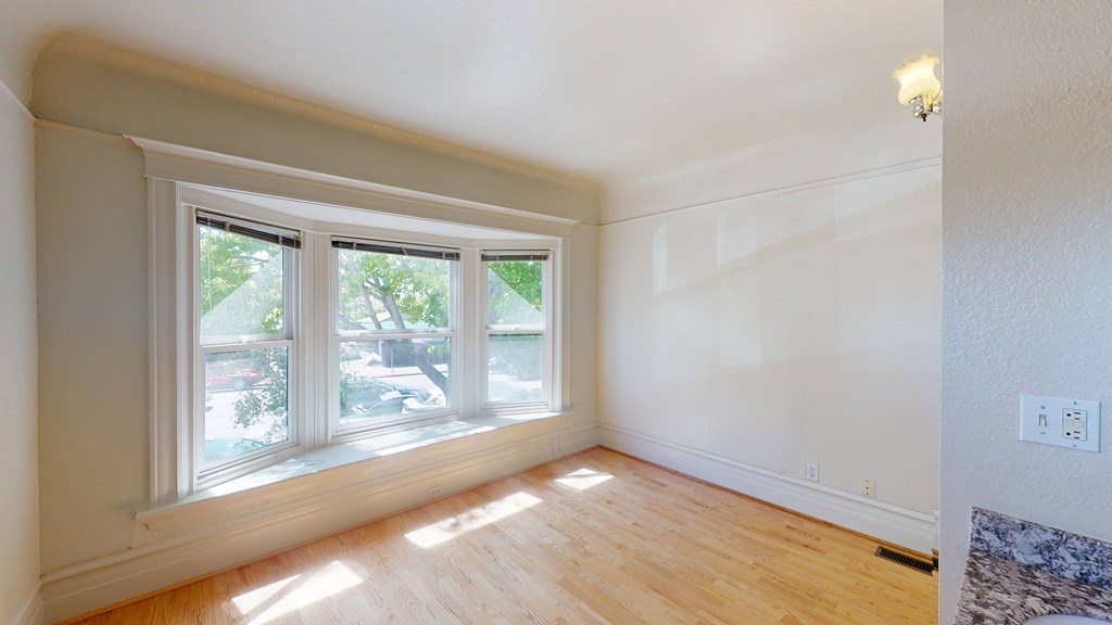 A room with a window and wooden floors.