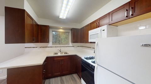 A white refrigerator is in a kitchen with brown cabinets.