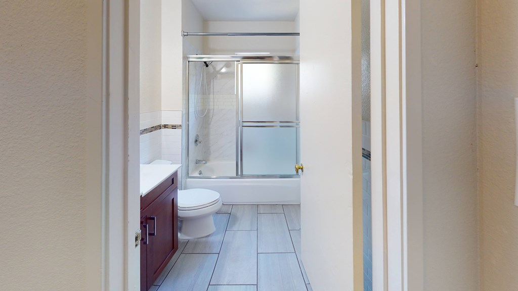 A bathroom with a toilet, sink, and shower.