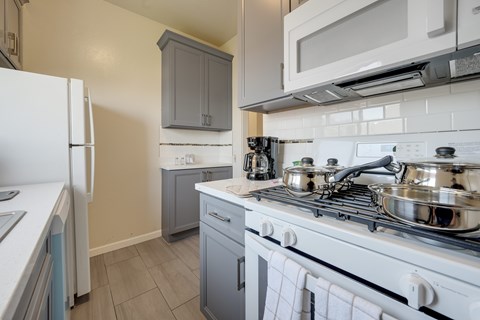 A kitchen with a white stove top oven and a white refrigerator.