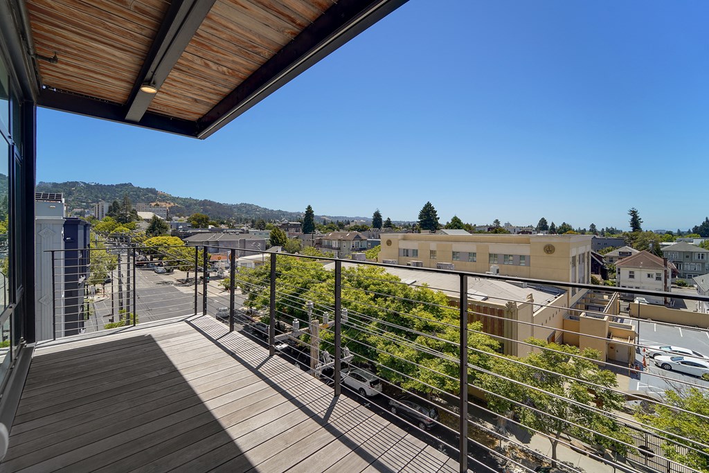 A balcony with a railing overlooks a town.