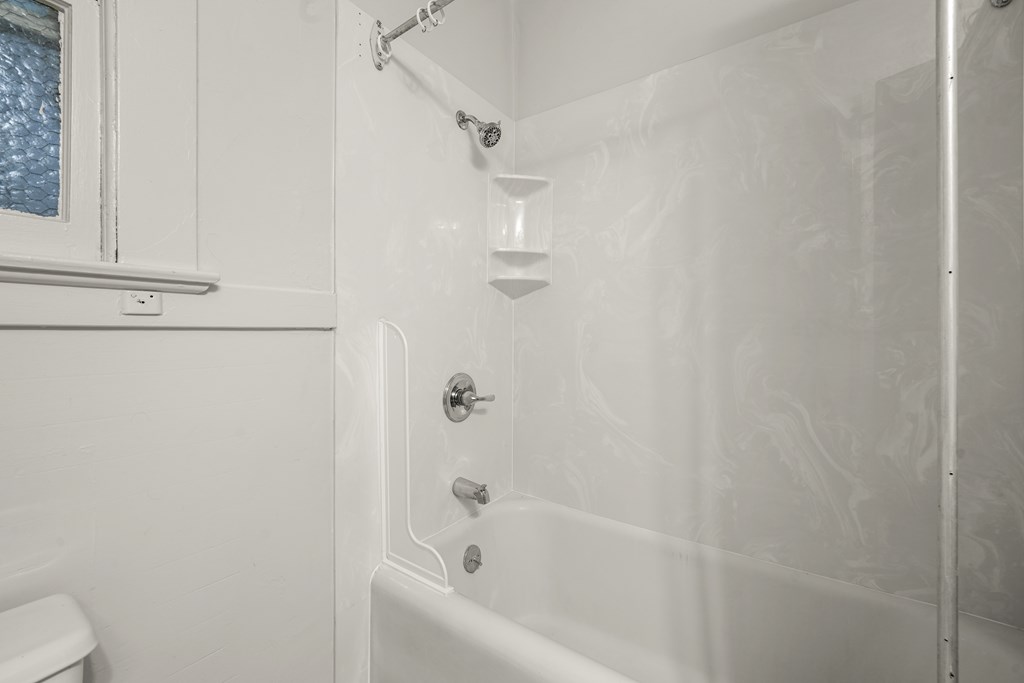 A white bathroom with a tub, toilet and sink.