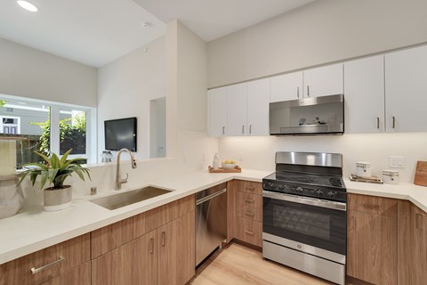 A modern kitchen with wooden cabinets and stainless steel appliances.