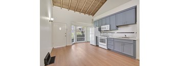 A kitchen with wooden floors and white appliances.