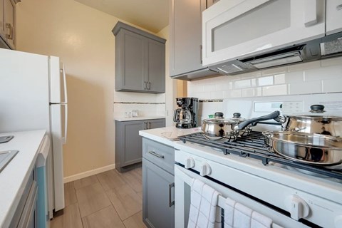 A kitchen with a white stove top oven and a white refrigerator.