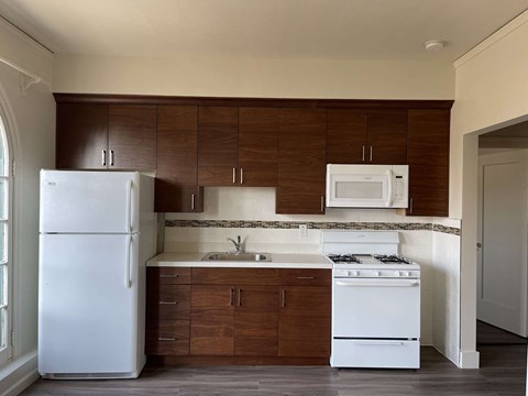 a kitchen with white appliances and wooden cabinets