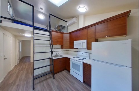 A kitchen with white appliances and wooden cabinets.