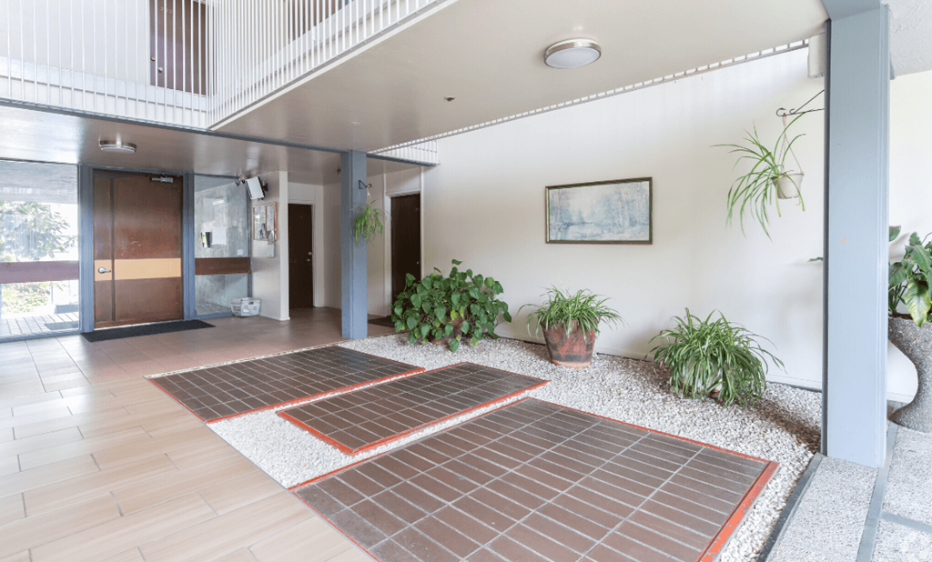 the entrance to a building with a lobby and potted plants