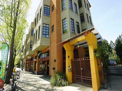 A yellow and brown building with a gate in front.