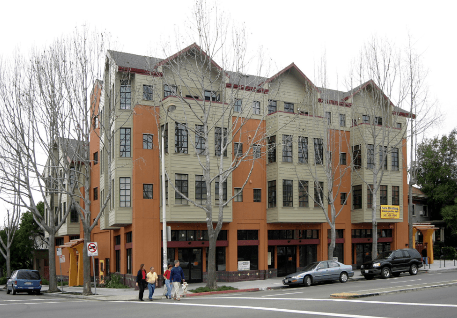 A multi-story building with a yellow sign on the ground floor.