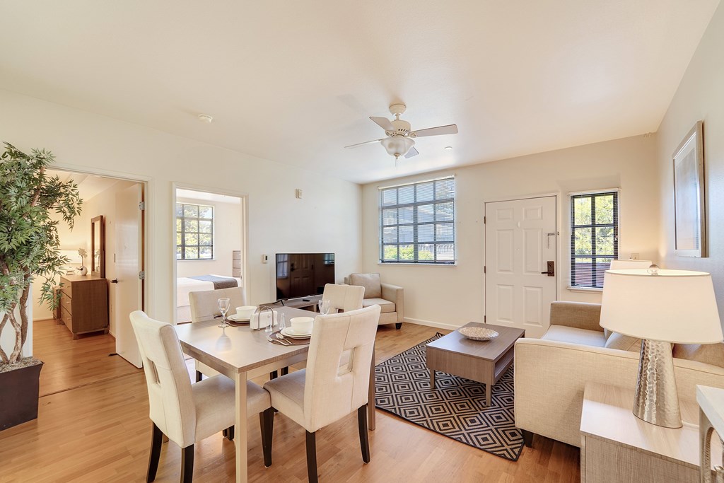 A well-lit, modern dining room with a table set for four.