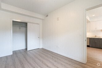 an empty room with a door to a kitchen