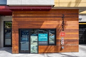 a wooden building with a door and a sign that reads now leasing