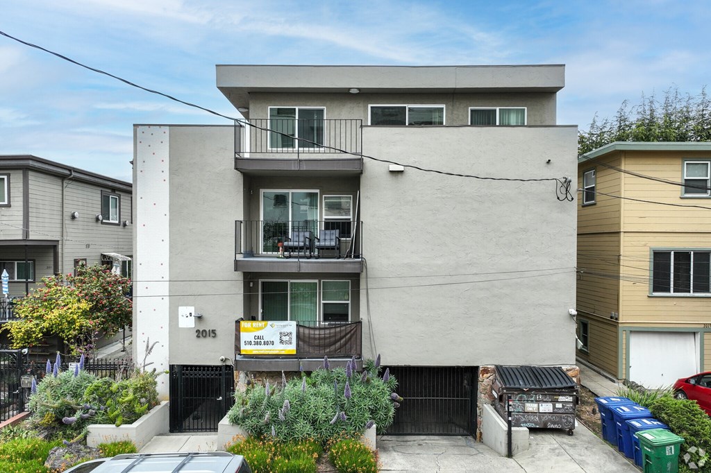 A modern two-story house with a balcony on the second floor.