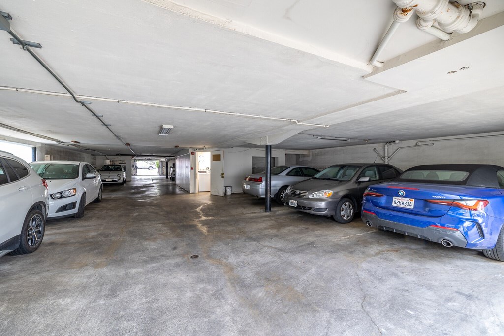 A parking garage with several cars parked inside.