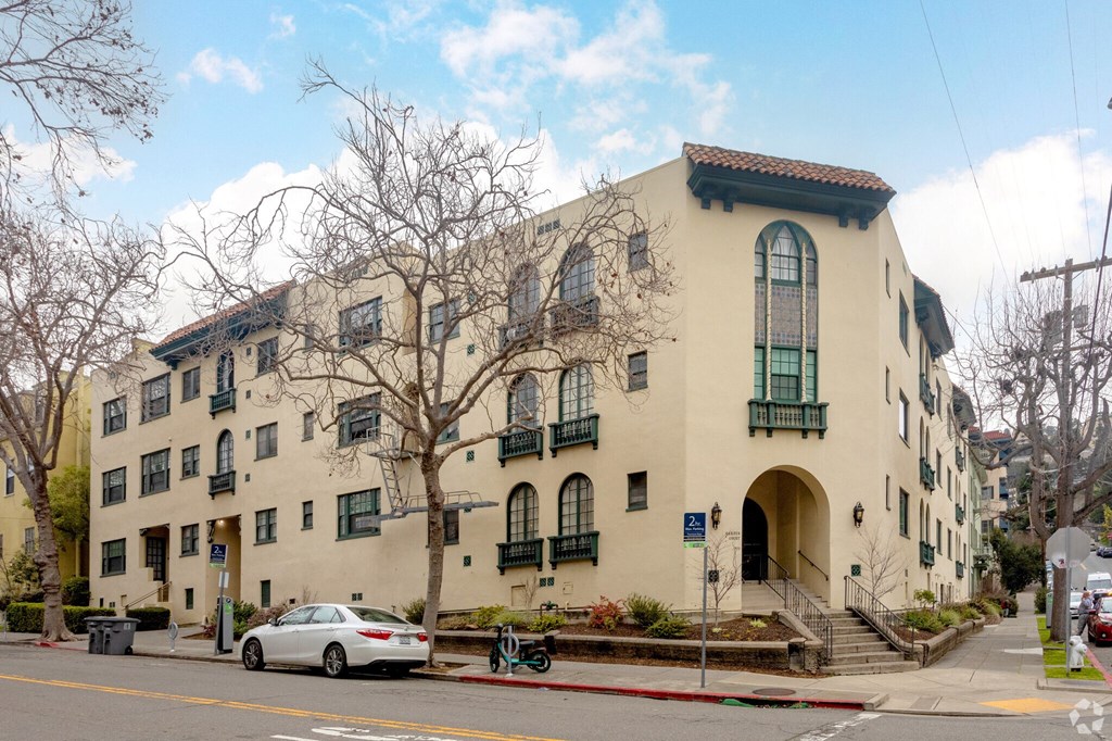 a large building on the corner of a street with a car